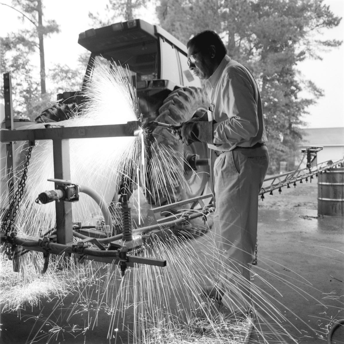<p><center>Bladen County, North Carolina:</center></p>
After designing a modification to convert his four-row sprayer to a machine capable to treating six rows at a time, Wright finishes some welding. " This modification will allow fewer trips through the field, cutting fuel costs and time in the field."</p> : Images : AMERICAN BLACK FARMERS PROJECT - John Ficara