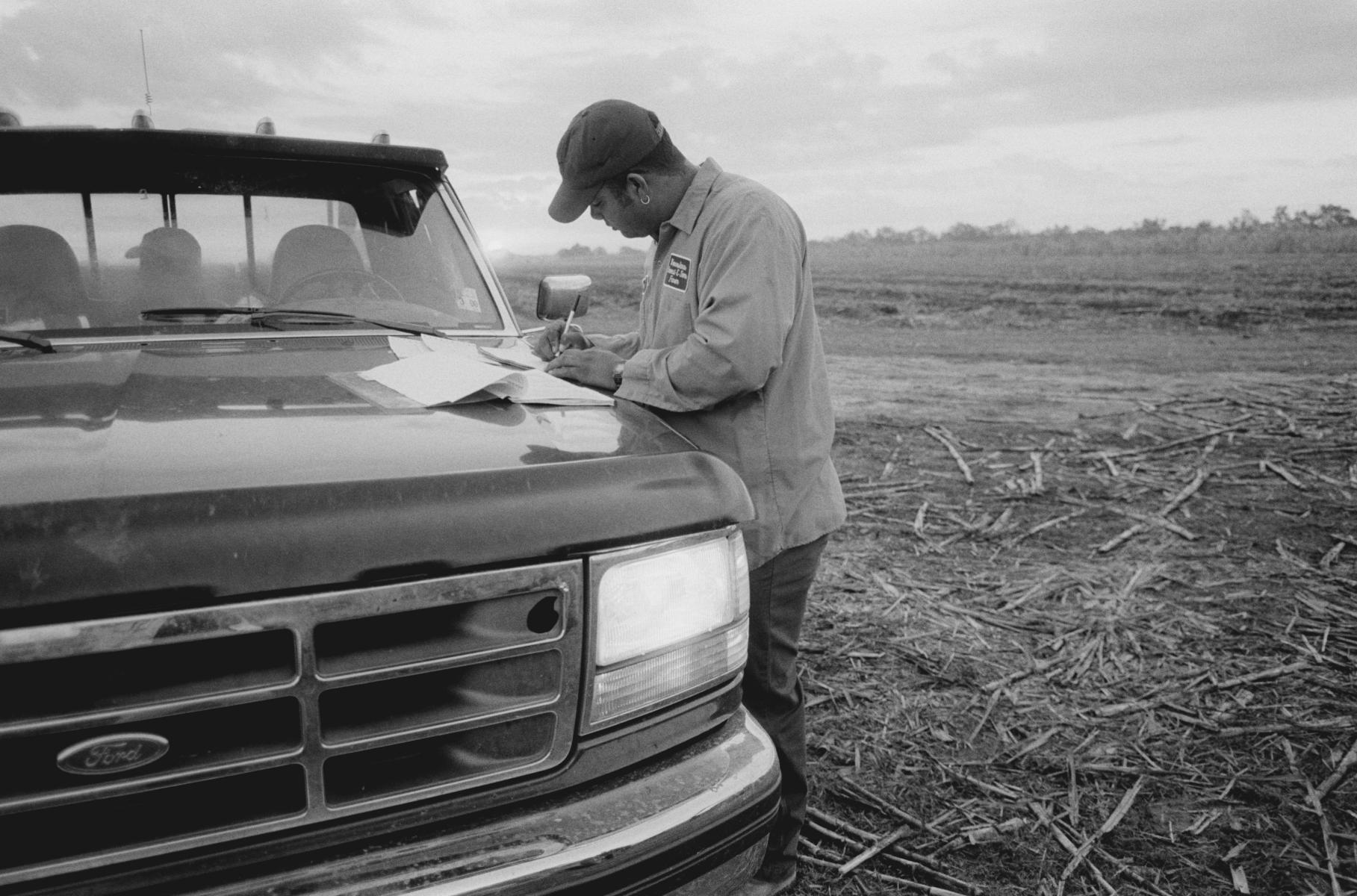 <p><center>Iberia Parish, Louisiana:</center></p>
June,  the youngest Provost brother, fills out the required paperwork that will accompany their trucks of sugarcane to the mill for testing of sugar content and weight. : Images : AMERICAN BLACK FARMERS PROJECT - John Ficara